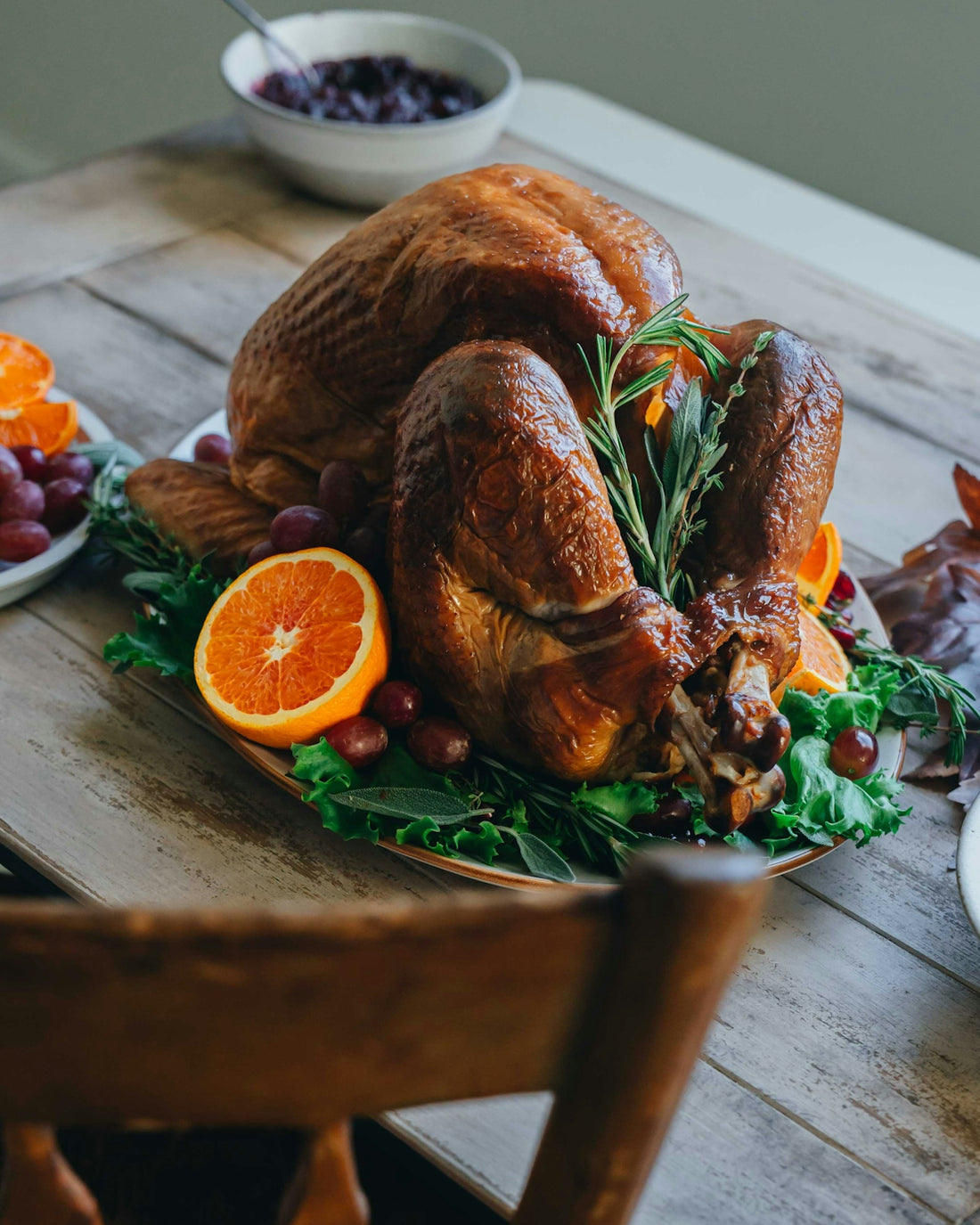 A golden roasted turkey garnished with oranges and rosemary